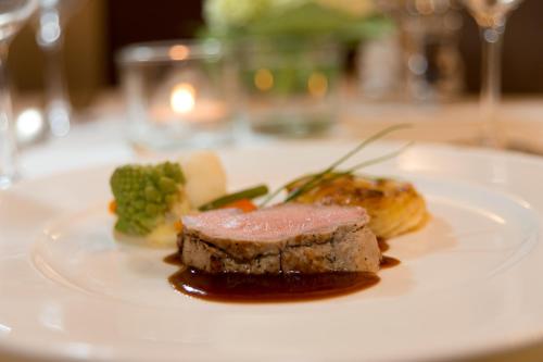 a white plate with a piece of food on a table at Hotel Vier Jahreszeiten in Silandro
