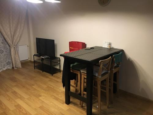 a black table with chairs and a television in a room at Apartments 315 New Gudauri 2 blok in Gudauri