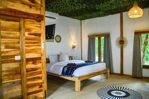 a bedroom with a bed in a room at Beda gaya ecolodge Rangsot 2 in Tanjung