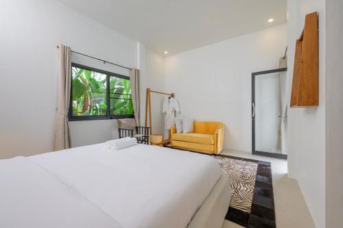 a bedroom with a white bed and a yellow chair at Savana- Wild Pool Villa I 6 en-suite bedrooms in Chiang Mai