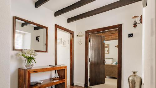 a hallway with a mirror and a wooden door at New Haven in Elie