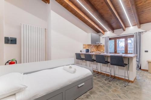 a kitchen with white walls and a bar with stools at EasyHome Malpensa Milano - self-check-in in Somma Lombardo