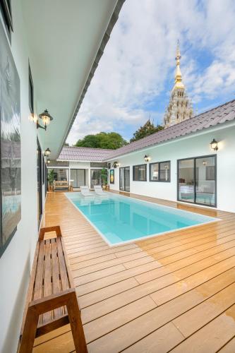 a swimming pool with a wooden deck and a bench at Savana- Wild Pool Villa I 6 en-suite bedrooms in Chiang Mai