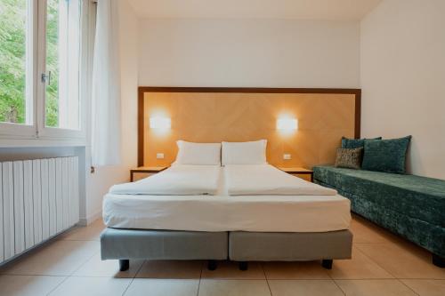 a bedroom with a large bed and a couch at Junior Depandance in Cavallino-Treporti