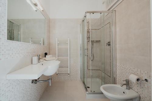 a white bathroom with a sink and a shower at Junior Depandance in Cavallino-Treporti