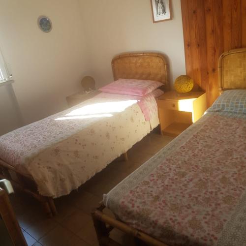a bedroom with two twin beds and a night stand at CONDOMINIO CESANO MARE in Marotta