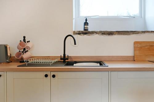 a kitchen counter with a sink and a window at Stylish Bakewell apartment -walk to cafes and river in Bakewell