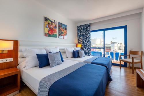 a hotel room with two beds and a balcony at Hotel Tahití Playa & Suites 4Sup in Santa Susanna
