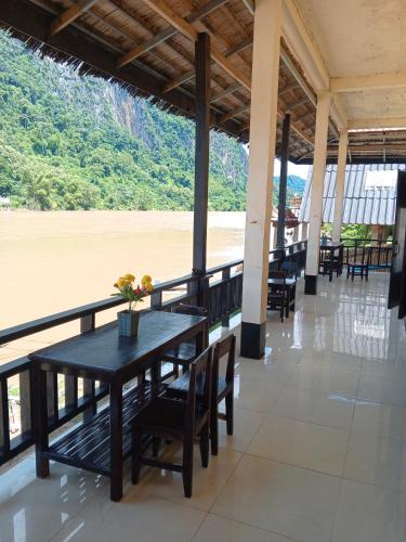a dining room with a table and chairs next to the beach at Dormitory Hostel Cam Uo in Nongkhiaw