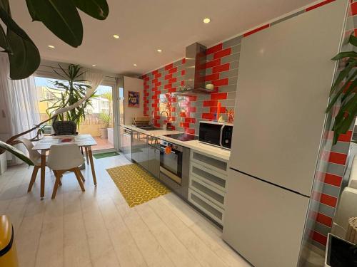 eine Küche mit einem weißen Kühlschrank und einem Tisch in der Unterkunft Roq duplex in Valras-Plage
