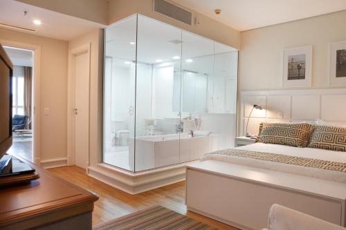 Un dormitorio con una gran ducha de cristal y una cama en Vitória Hotel Concept Campinas, en Campinas