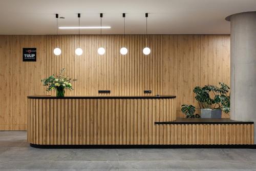 a lobby with a reception counter with flowers on it at TULIP Residences Lviv in Lviv