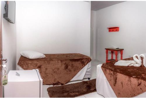a room with two beds and a table at Hotel Pousada Caranda Eco Ville in Bonito