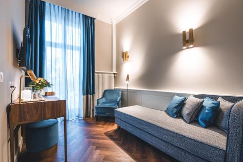 a living room with a couch and a chair in a room at Hotel Reine Victoria in St. Moritz