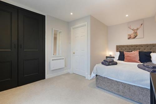 a bedroom with a bed and a black door at Stylish Bakewell apartment -walk to cafes and river in Bakewell