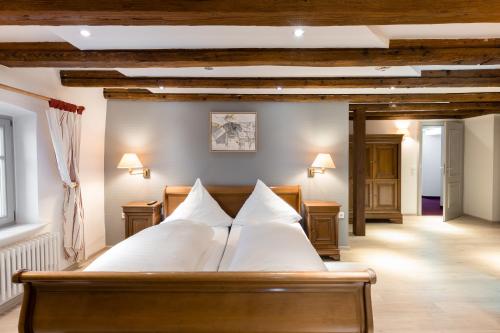 a bedroom with a large bed with white pillows at Eventlocation & Hotel Schloss Neuburg in Obrigheim