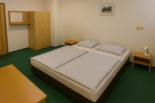 a small bedroom with a bed and a cabinet at Pension na hranici in Železná Ruda