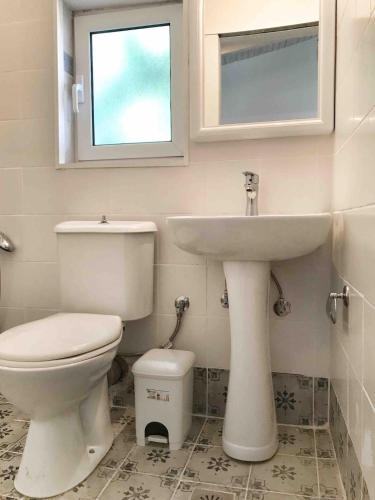ein Badezimmer mit Toilette und Waschbecken in der Unterkunft Kasimiotis studio in Koroni