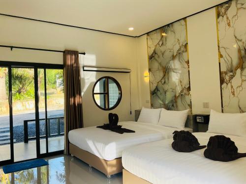 two beds in a room with a mirror at Lanta Beautiful beach house 1 in Phra Ae beach