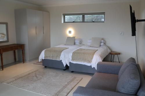 a bedroom with a bed and a couch at Sarah's Place -Stilbaai in Stilbaai
