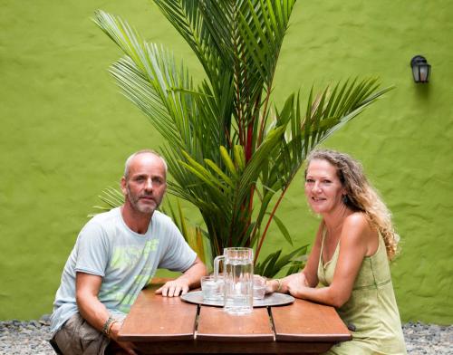 Ein Mann und eine Frau sitzen an einem Tisch in der Unterkunft Red Pepper Popoyo in Popoyo