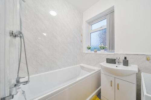 a white bathroom with a tub and a sink at Contractor-friendly Home in Stoke with Free Parking in Stoke on Trent