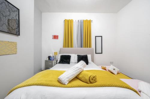 a bedroom with a large bed with a yellow blanket at Contractor-friendly Home in Stoke with Free Parking in Stoke on Trent