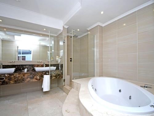 a large bathroom with a tub and a shower at Orchids Lodge in Fourways