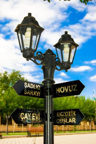a street light with street signs on it at Vilesh Palace Hotel in Masallı