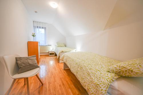 a bedroom with two beds and a chair in it at Green View Kamnik in Kamnik