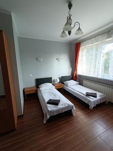 a bedroom with two beds and a window at Hotelik -Świerki in Swarzędz