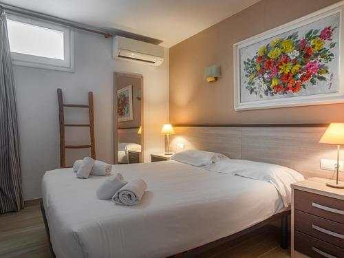 a bedroom with a large white bed with towels on it at Playa Canadell MAR P primera línea de mar con terraza - WeHost Costa Brava in Calella de Palafrugell