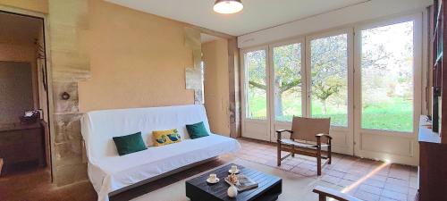 a living room with a white couch and some windows at La Mondee in Badefols-dʼAns