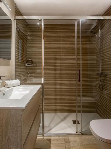 a bathroom with a shower and a sink and a toilet at Playa Canadell MAR P primera línea de mar con terraza - WeHost Costa Brava in Calella de Palafrugell