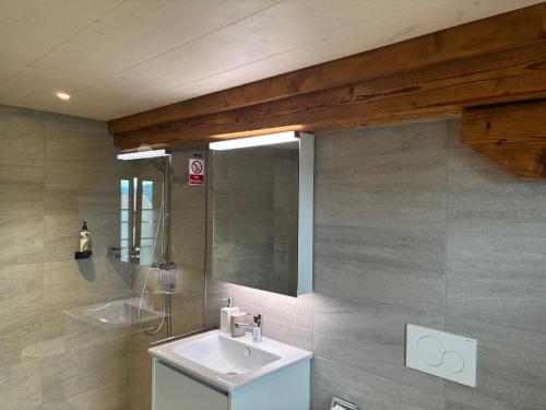 a bathroom with a sink and a mirror at Apartment Bärgli in Krattigen in Krattigen