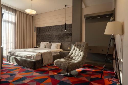 a bedroom with a bed and a chair at Element in Alba Iulia