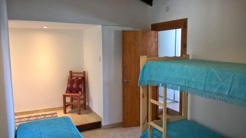 una habitación con una litera y una silla en Playa 1, en Villa Gesell
