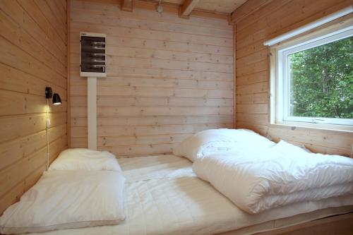 a room with two beds in a wooden cabin at Hedebo Strand Camping in Sæby