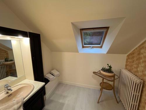 a bathroom with a sink and a window at Domaine du moulin de la plaine in Trôo
