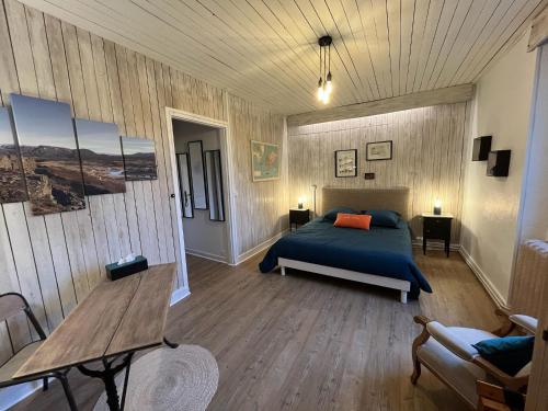 a bedroom with a bed and a wooden wall at Domaine du moulin de la plaine in Trôo