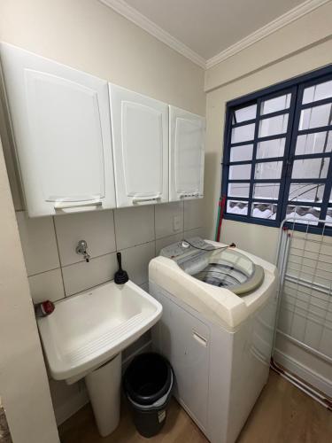 a small bathroom with a toilet and a sink at Ipê Rosa Apartamento in Brasília