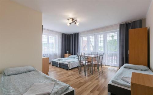 a room with two beds and a table and a dining room at Noclegi Michaś in Krasnobród