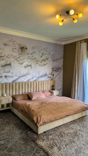 a bedroom with a large bed with a wall at Hide Out Lake Villa Uganda in Bwerenga