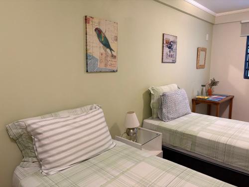 a bedroom with two beds and a bird on the wall at Ipê Rosa Apartamento in Brasília