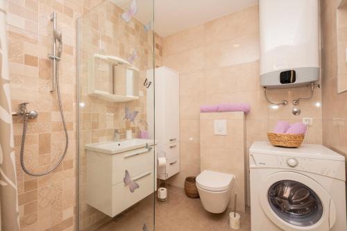 a bathroom with a washing machine and a shower at Nika Vacation House in Zavojane