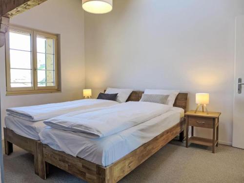 a bedroom with a large wooden bed with two lamps at Apartment Bärgli in Krattigen in Krattigen