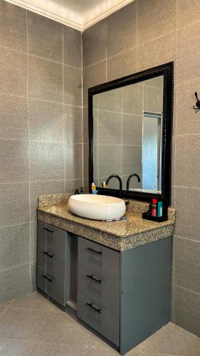 a bathroom with a sink and a mirror at Hide Out Lake Villa Uganda in Bwerenga