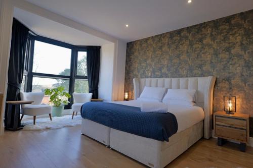 a bedroom with a large bed and a window at The Tall Trees Hotel in Amlwch