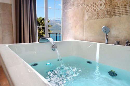 a swimming pool with a bathtub and a large tub at Hotel Gajeta in Gaeta