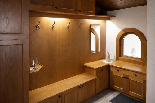 a bathroom with wood paneling and a sink and mirrors at Apartment Fischer in Tarrenz